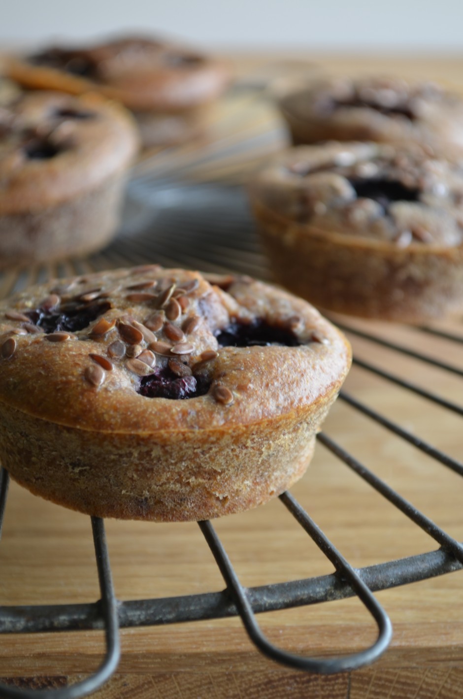 A photo of blueberry banana breakfast muffins, topped with flaxseed. Photo and recipe by That Healthy Kitchen