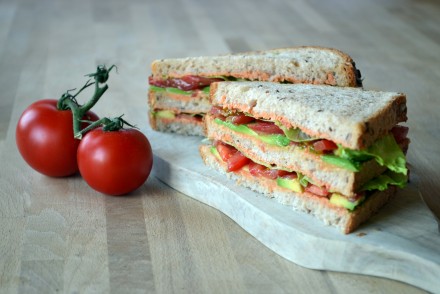 A photo of a clubsandwich with tomato, avocado, iceberg lettuce and tomato hummus. Recipe by That Healthy Kitchen