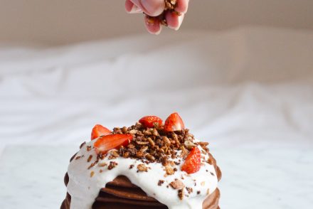 Chocolate pancakes topped with a greek yoghurt vanilla cream, fresh strawberries and chocolate granola