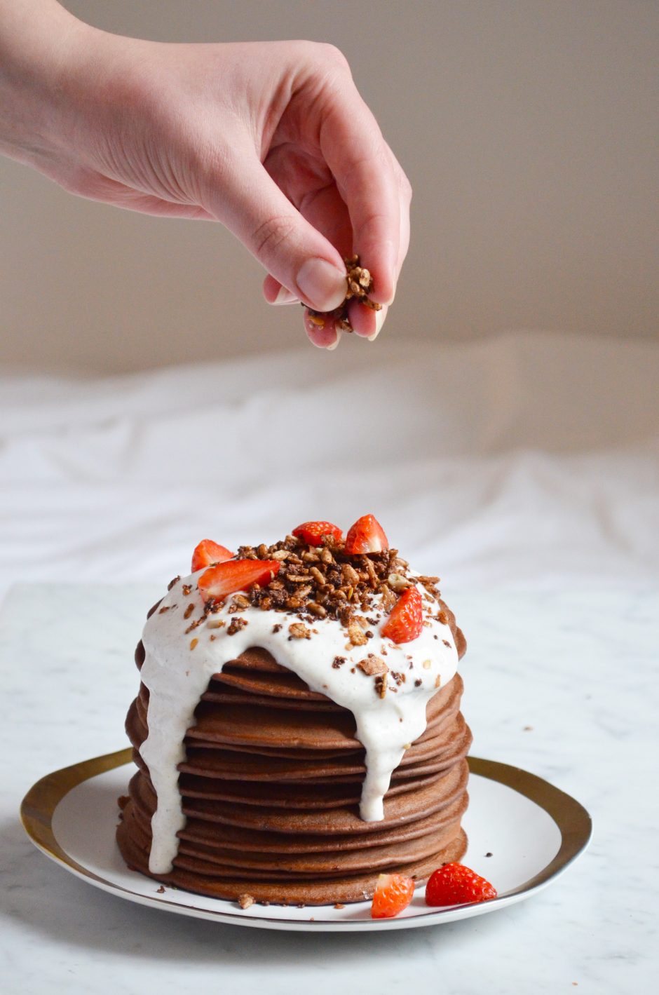 Chocolate pancakes topped with a greek yoghurt vanilla cream, fresh strawberries and chocolate granola