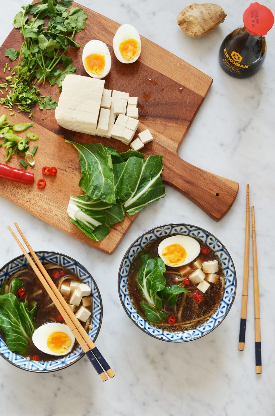 Recipe for spicy homemade ramen broth with all the toppings, including tofu, soft boiled eggs, fresh cilantro, red chili peppers, green onion, bok choy and buckwheat noodles. Gluten free!