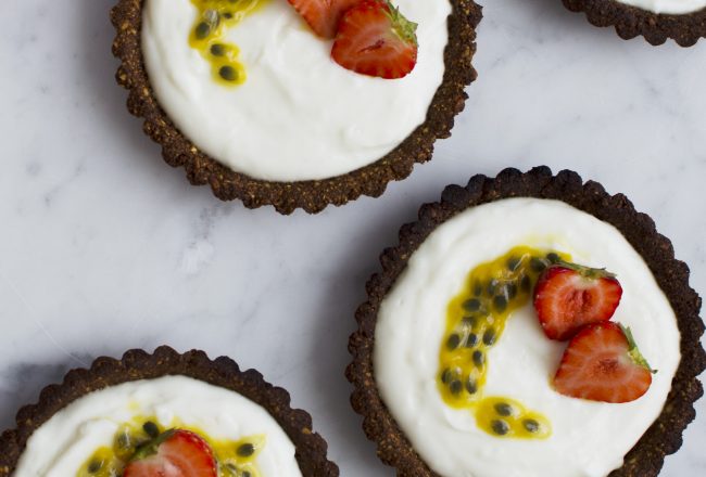 Five ingredient, vegan, gluten-free and whole foods apricot tartelettes / tartlets with cashew cream, strawberries and passion fruit. Recipe via That Healthy Kitchen